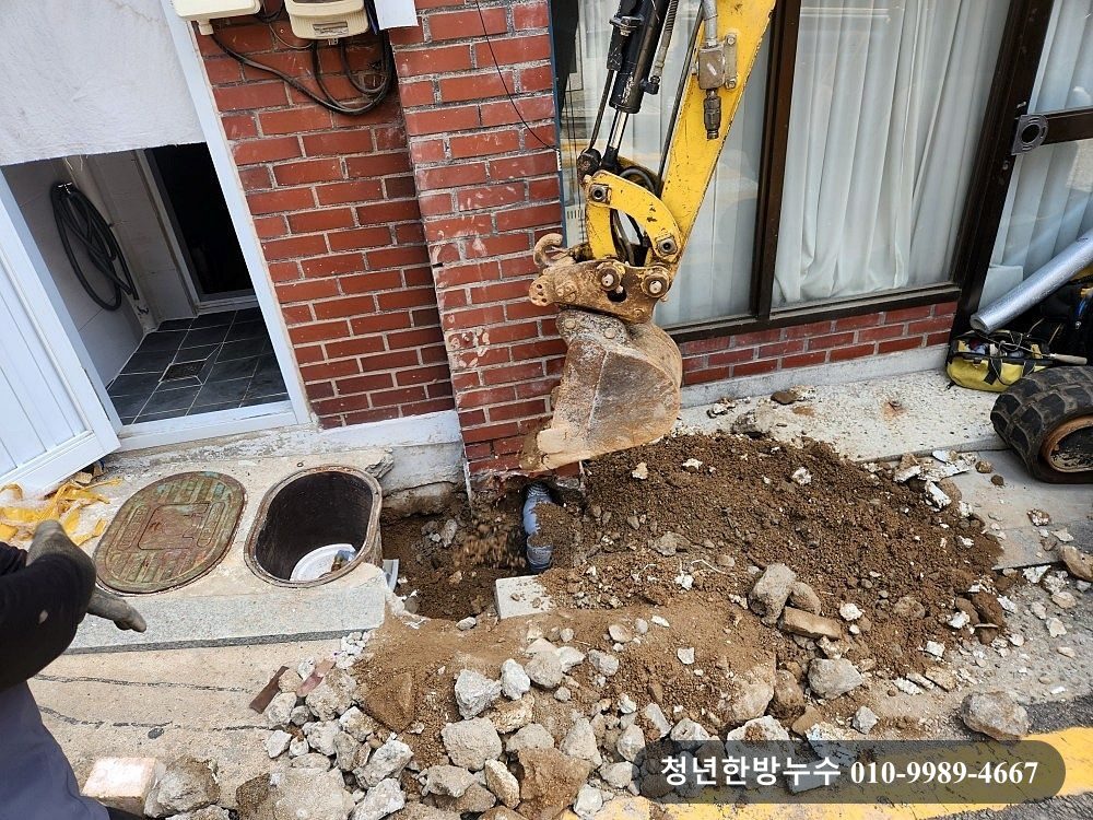 건물 외벽 주변 바닥을 굴착하는 모습입니다.